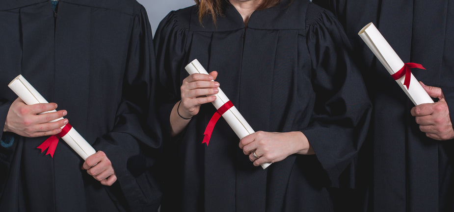 three-students-holding-diplomas